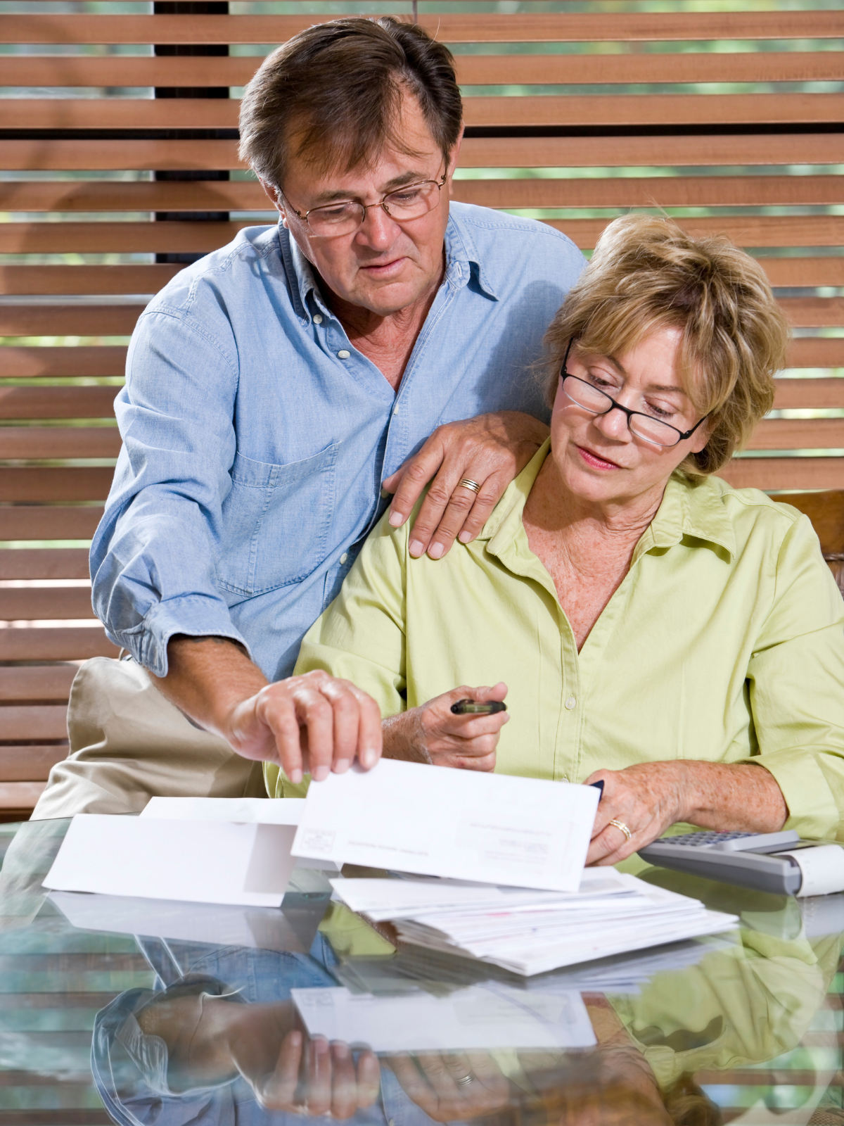 Concerned couple reviewing timeshare paperwork and financial documents while exploring timeshare debt relief and cancellation options.